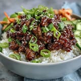 Sizzling gochujang-spiced Korean Ground Beef Bowl with edamame and fresh veggies ready to serve hot.