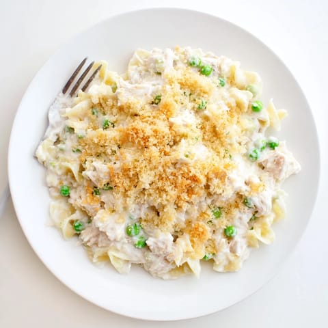 Freshly baked Tuna Casserole bubbling from the oven, its savory aroma filling the kitchen, served beside a crisp salad.