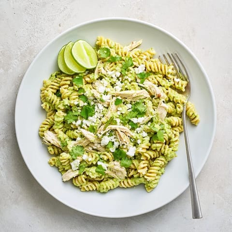 A close-up of bright green cilantro-lime yogurt sauce clinging to tender rotini and juicy chicken, perfect for a fresh weeknight meal.  
