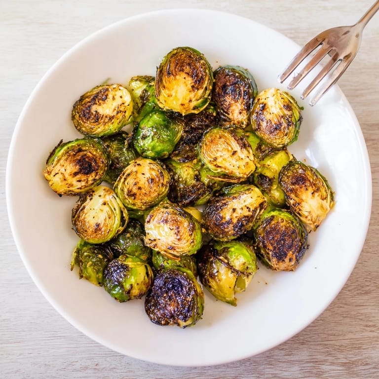 Freshly roasted Roasted Brussels Sprouts tossed in olive oil and spices, paired with a lemon wedge for serving.